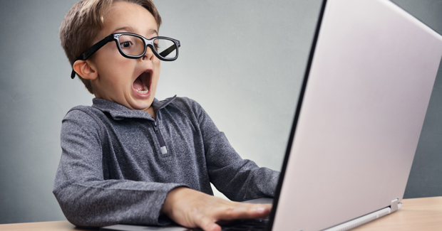 Boy trying to keep up with media on laptop