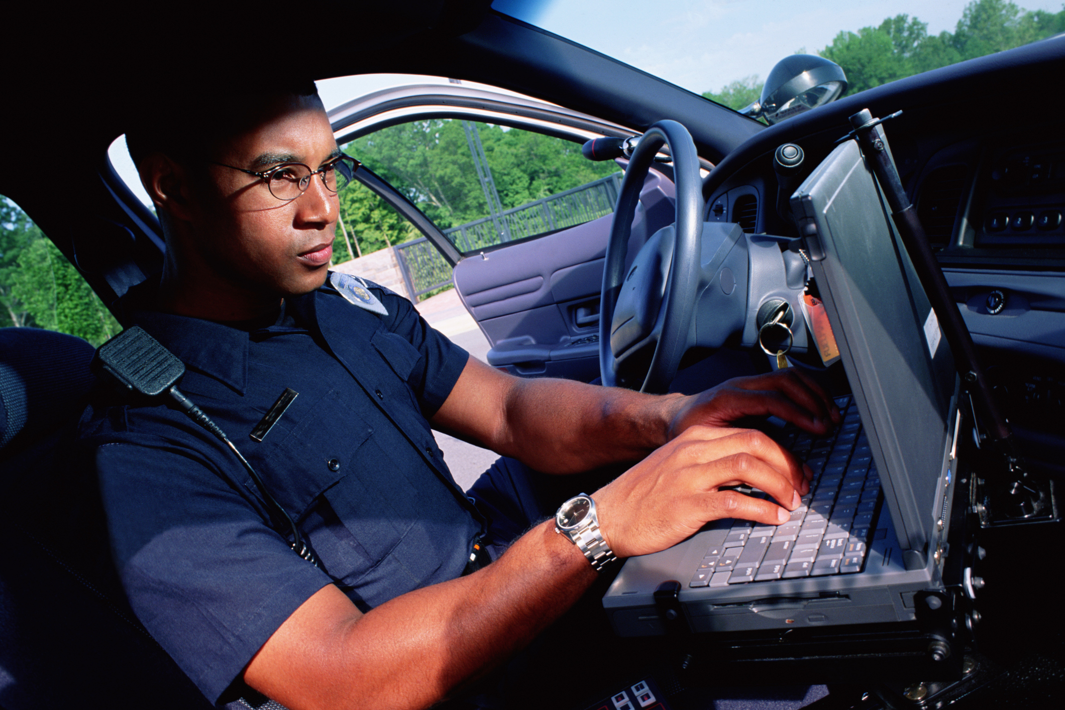 Policeman working on computer in car