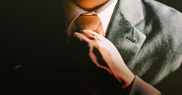 Business man adjusting tie