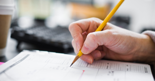 Businesswoman Writing in Weekly Organizer