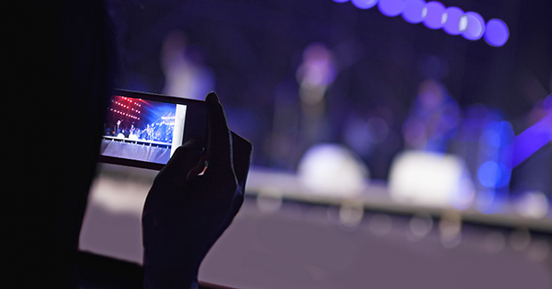 person taking a photo at a concert